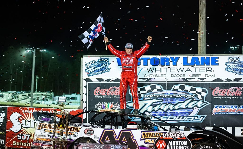 Madden stands on his car and celebrates in victory lane.
